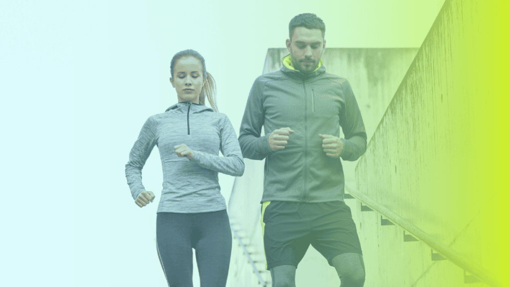 A woman and a man in athletic wear jog up outdoor stairs, highlighting the importance of corporates wellness. The lighting features a striking greenish-yellow gradient effect.