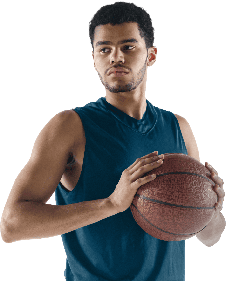 A young man in a sleeveless navy Coya shirt holds a basketball with both hands, looking to the side against a white background.