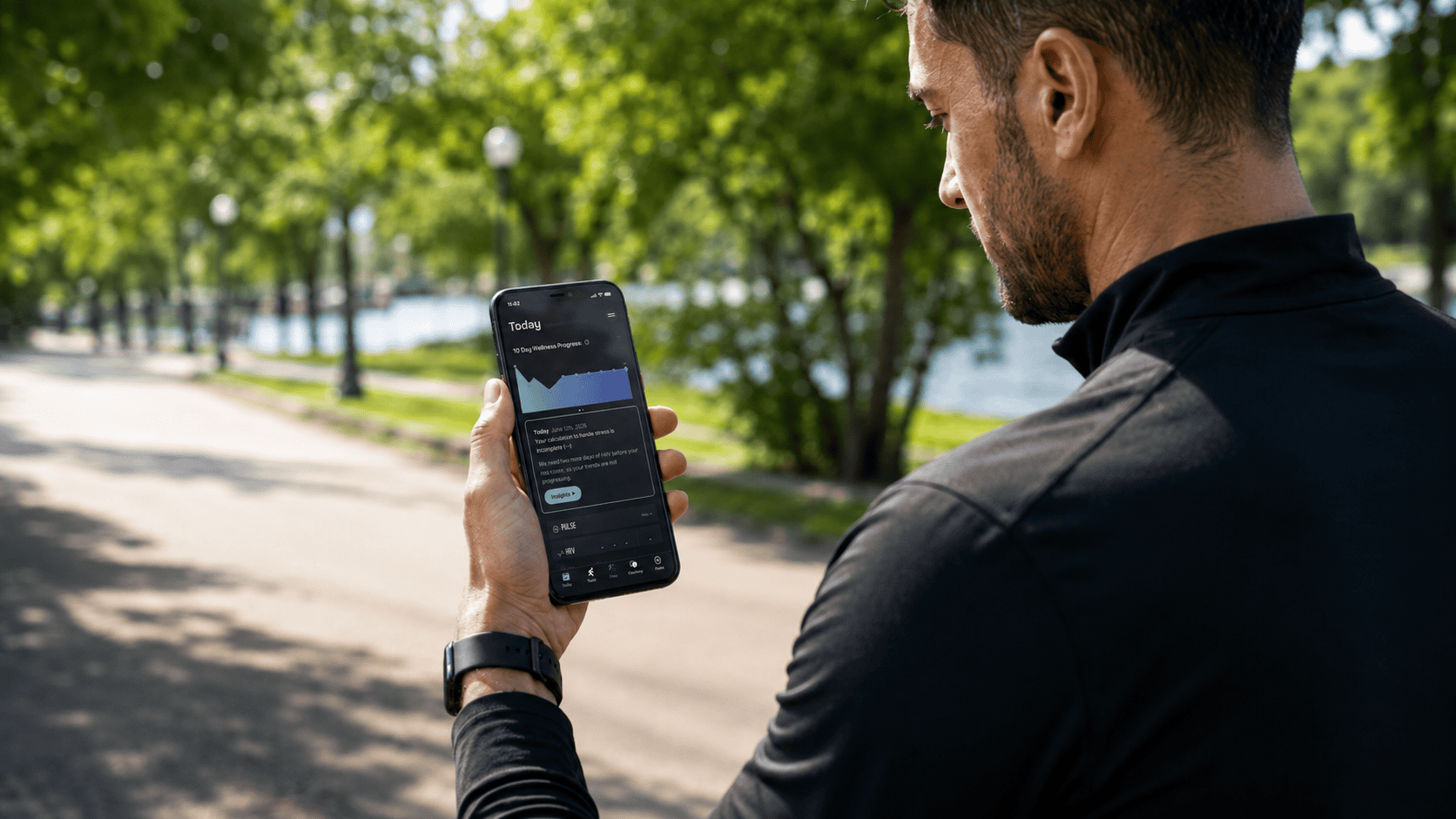 Coya mobile app user checking notifications on smartphone outdoors in a park with green trees and su.