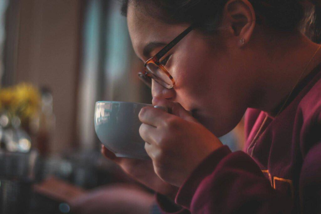 Woman drinking hot cup of coffee. Warm morning mug of coffee.